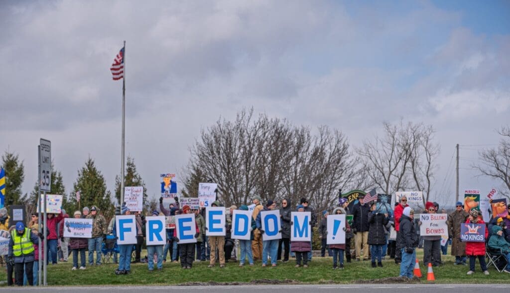 Protesters holding large FREEDOM letters and signs
