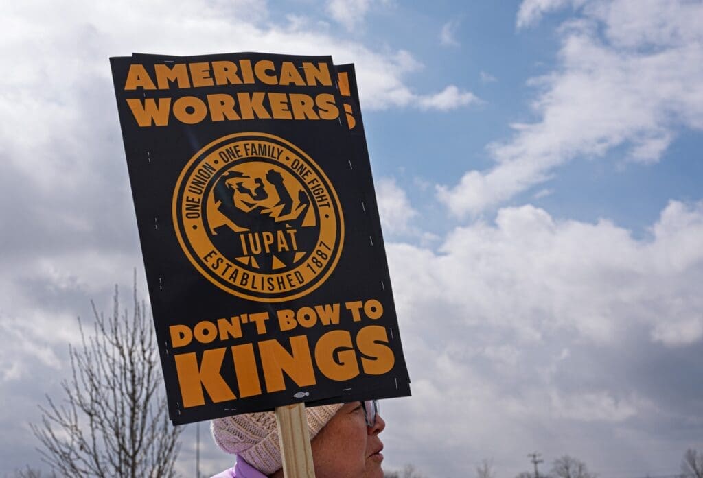 Protester holding American Workers union sign outdoors
