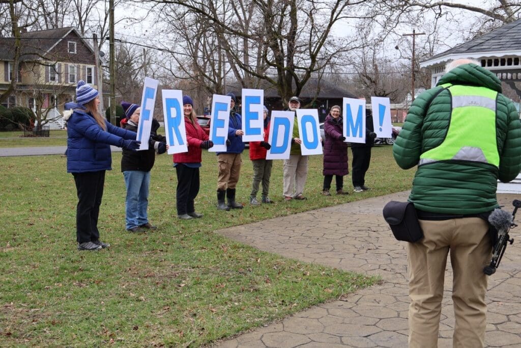 People holding FREEDOM letters in park