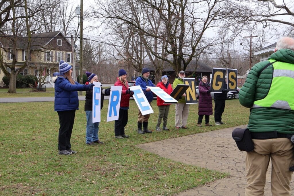 Group holding large FREE NGS letters outdoors