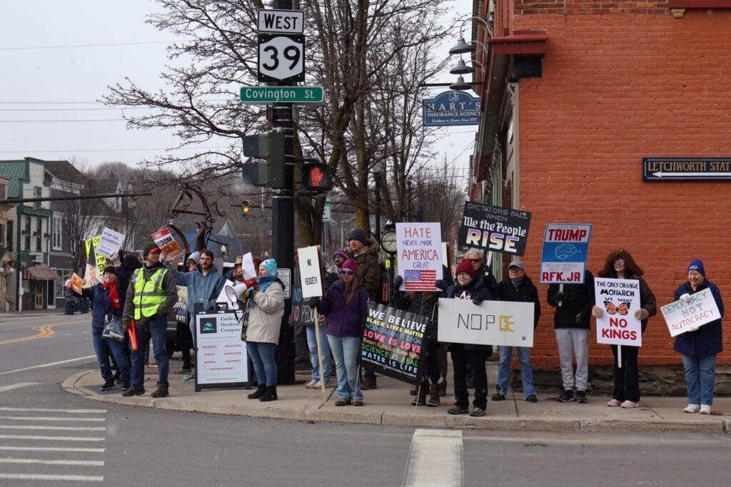 Protesters holding political signs on street corner