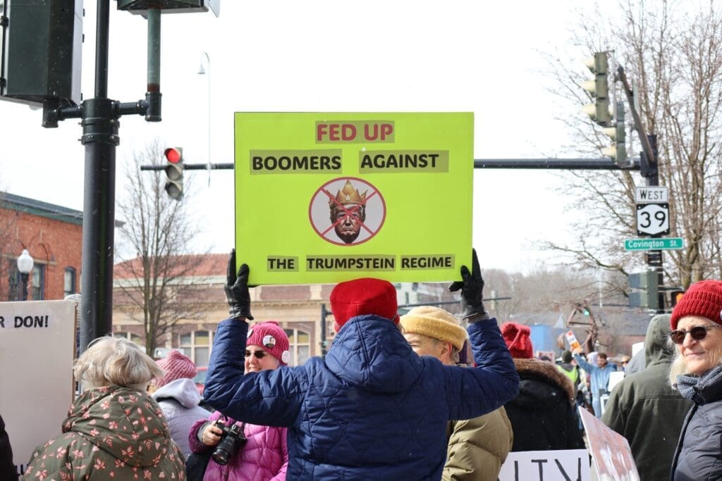 Protester holding anti-Trump sign at street rally