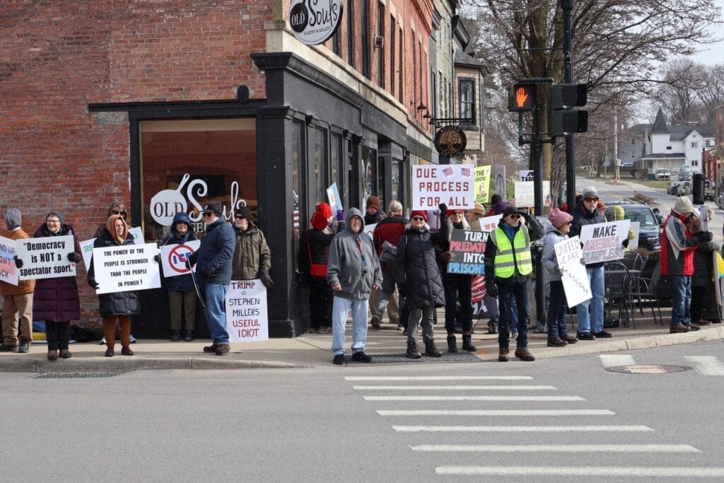 Protesters holding political signs on street corner