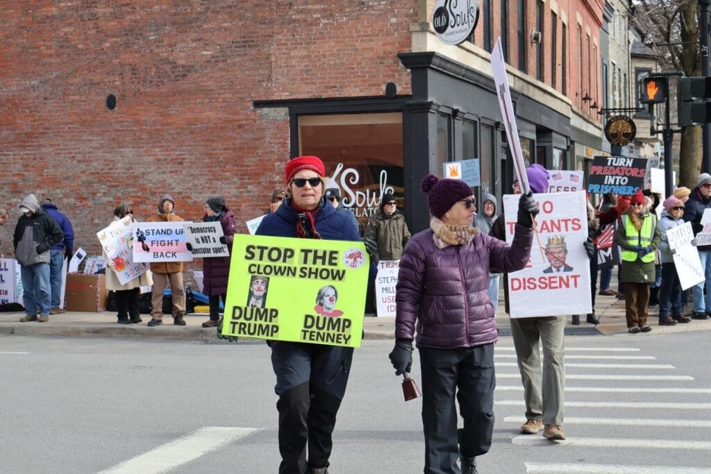 Protesters holding anti-Trump signs on city street