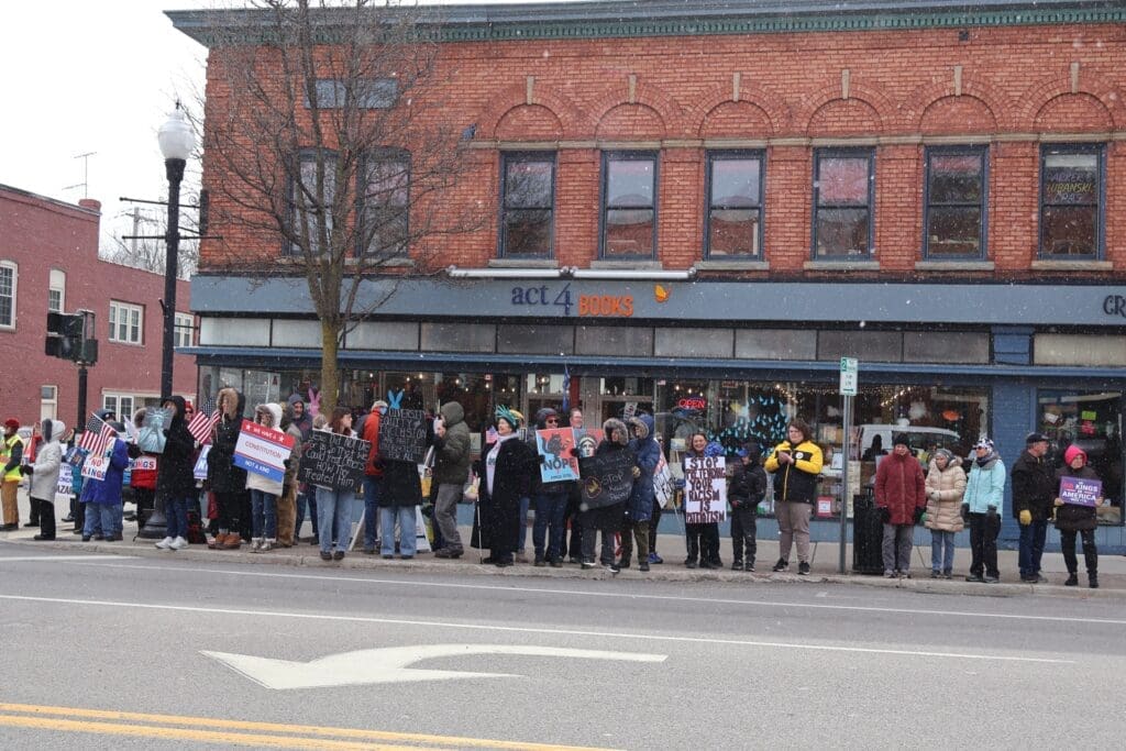 Protesters holding signs outside bookstore in snowfall