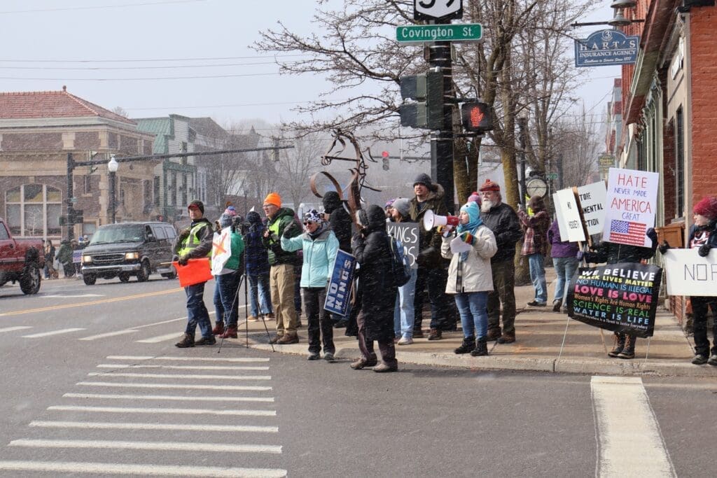 Protesters holding signs on snowy street corner