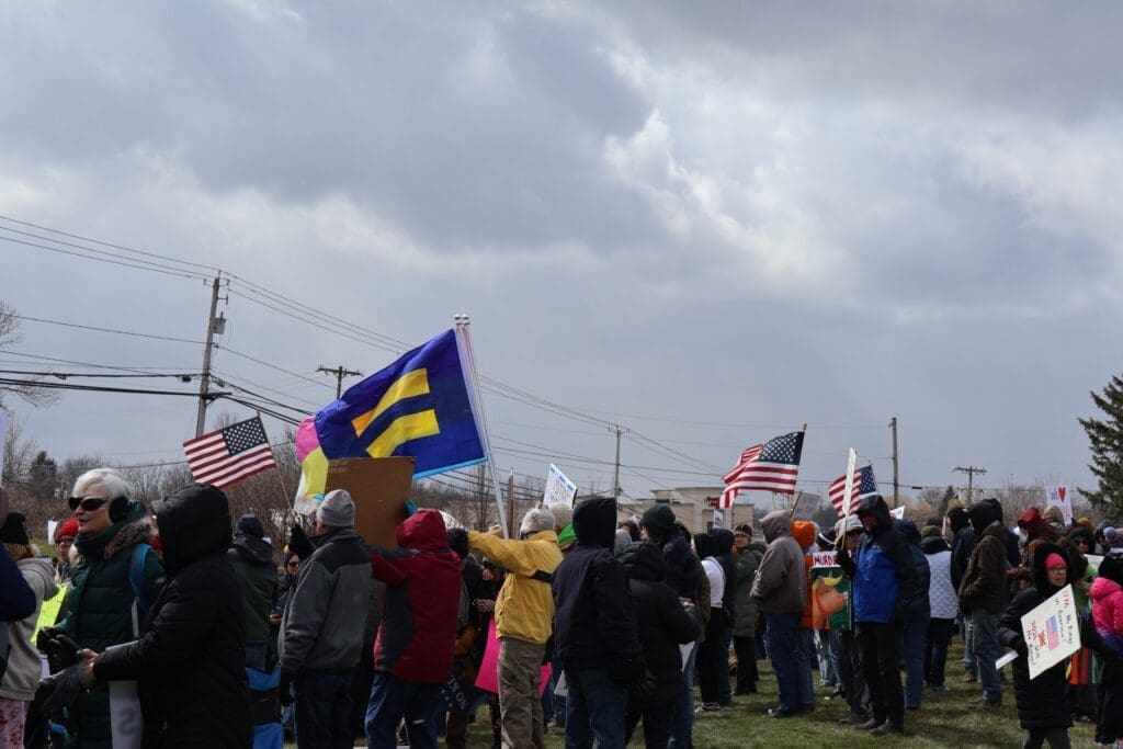 Crowd at protest with American and equality flags