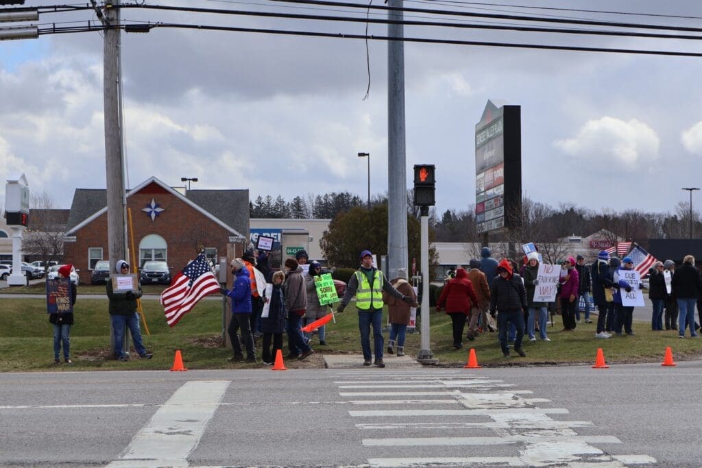Protesters with American flags at street intersection