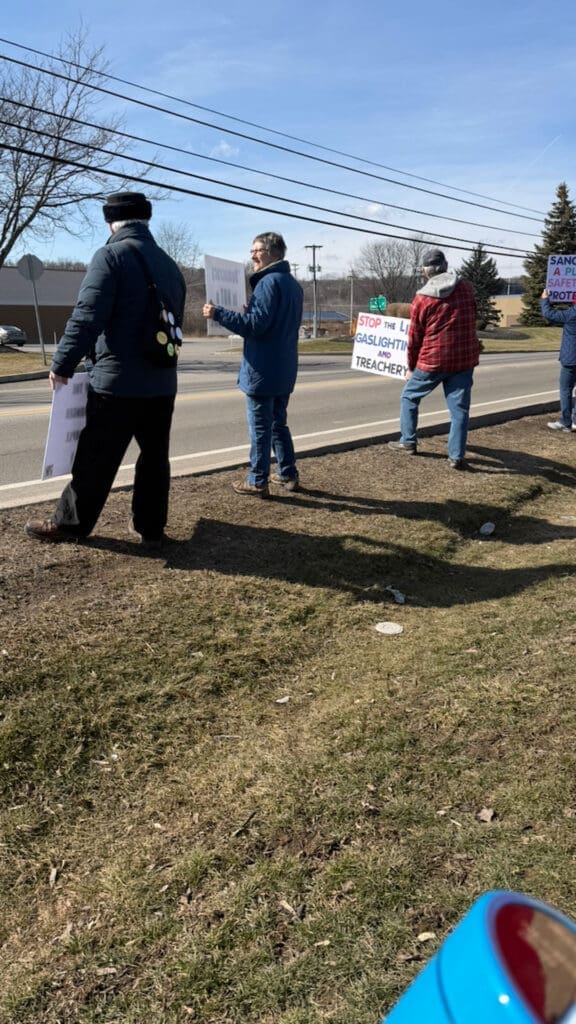 Protesters with signs demonstrating on roadside
