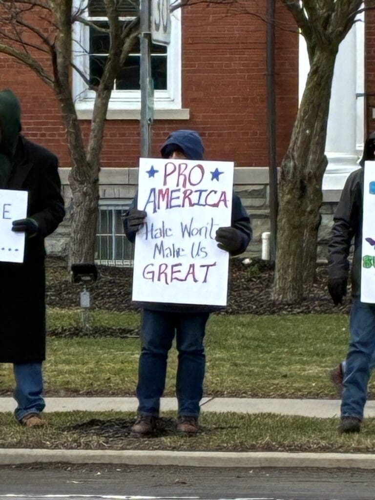 Person holding pro-America protest sign outdoors