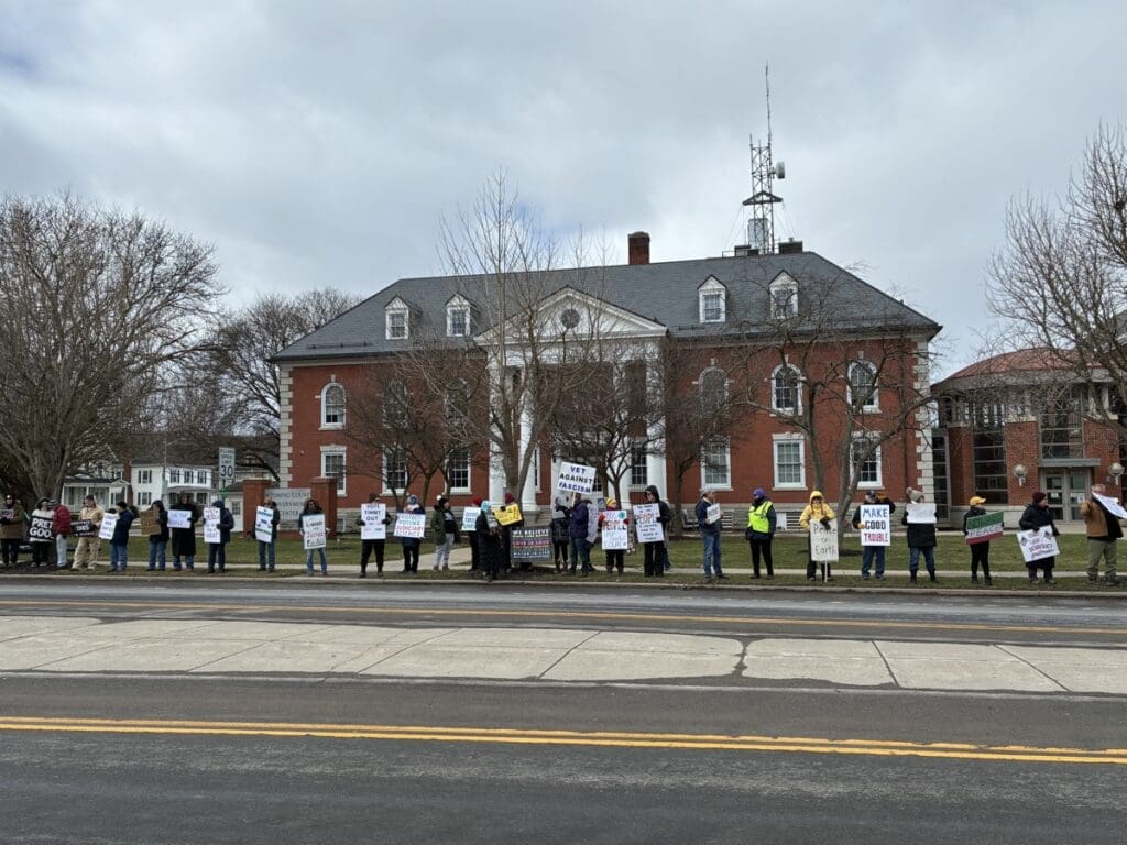 Protesters holding signs outside historic brick courthouse