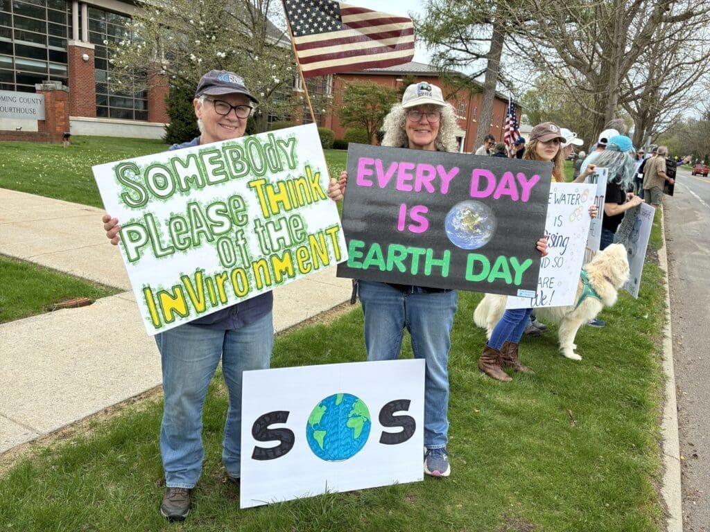 Protesters holding Earth Day environmental signs outdoors
