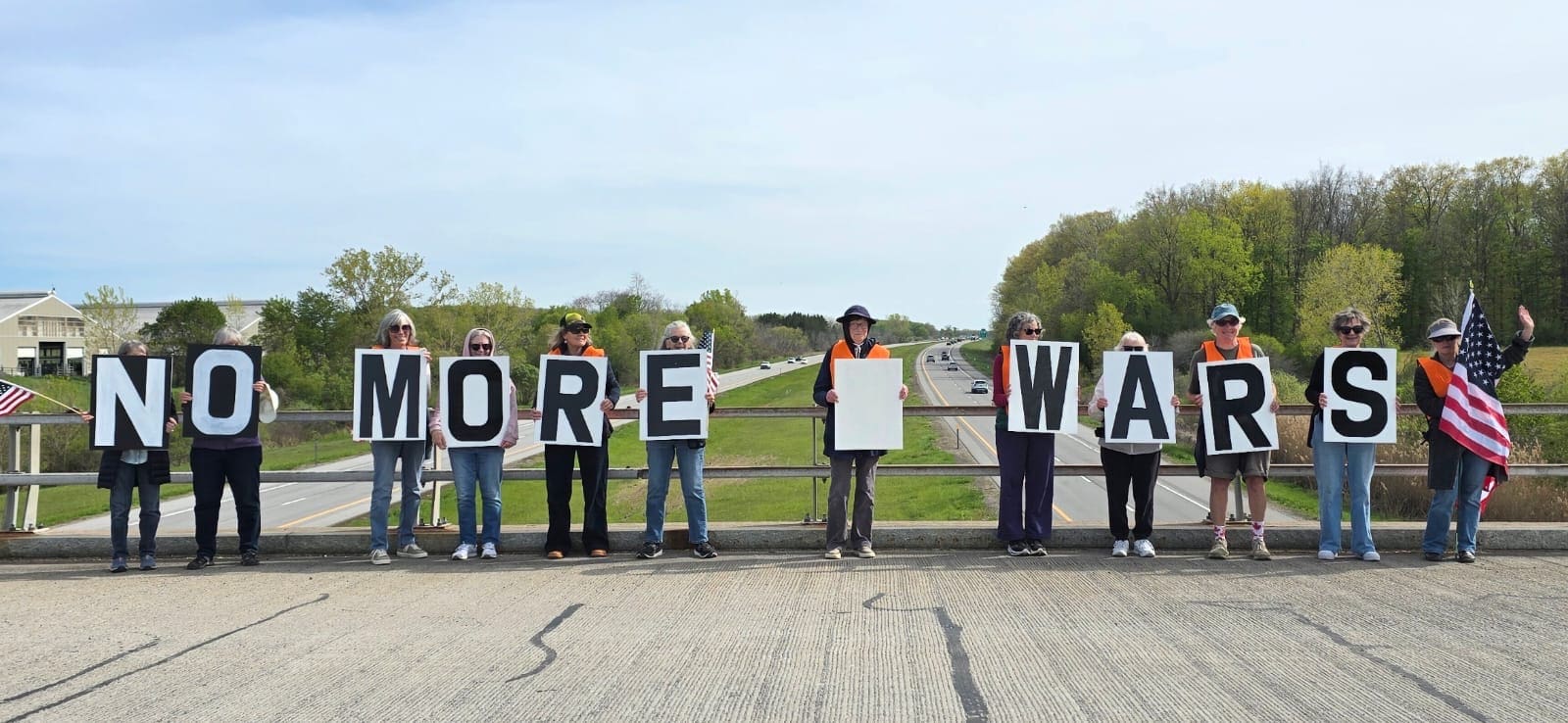Livingston Bridge Brigade activists raising signs over Route 390