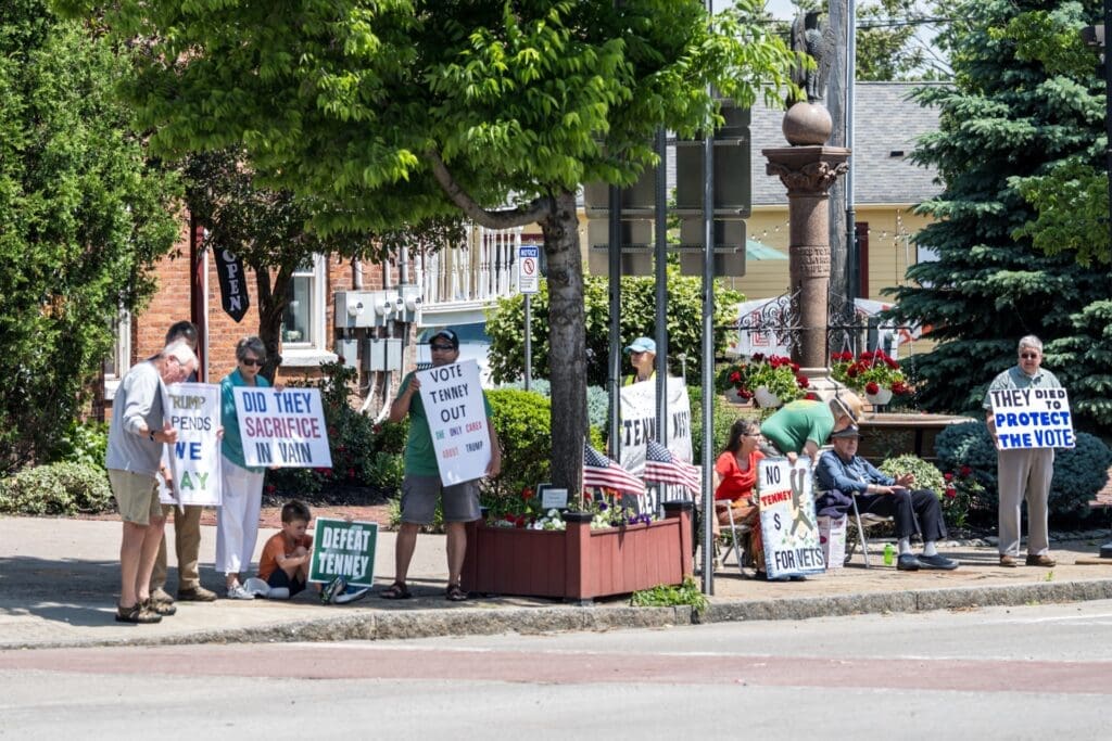 Protesters holding anti-Tenney political signs on a street corner