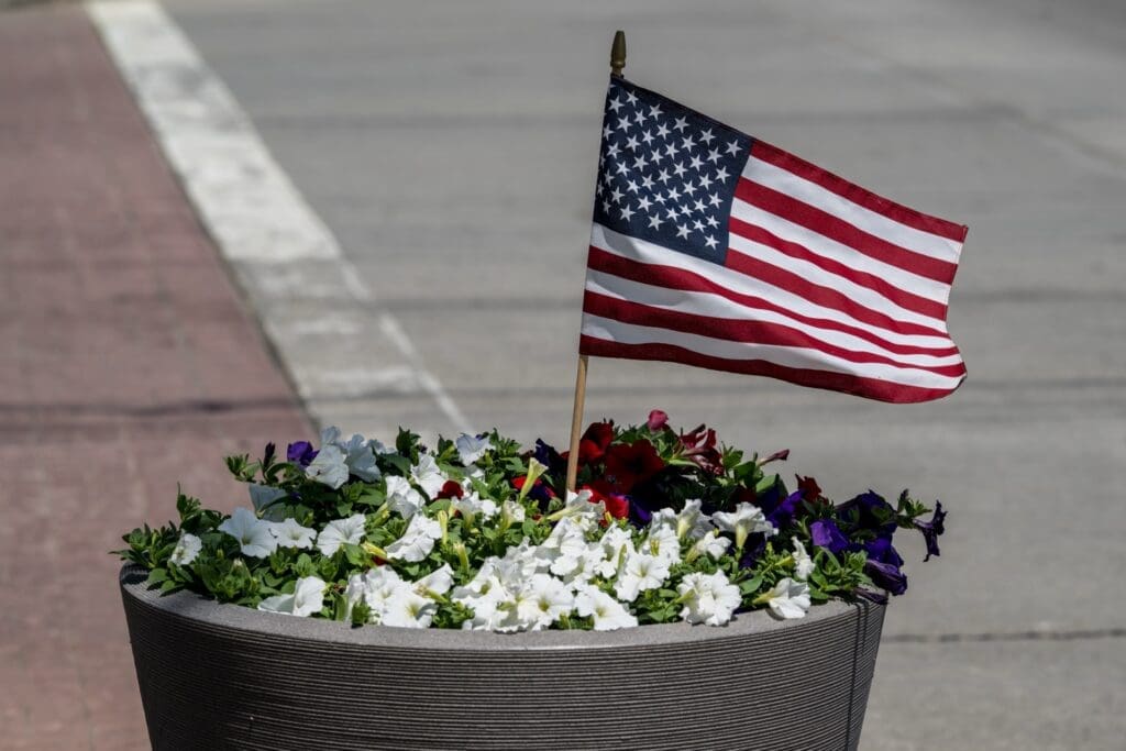 American flag in a flower planter with colorful blooms